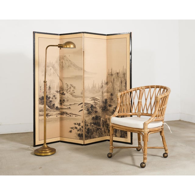 A classic mid-century modern style adjustable pharmacy floor lamp featuring a patinated brass finish and domed metal...