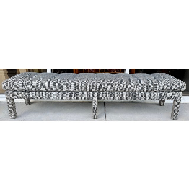 Extra long upholstered bench, featuring a navy blue and beige herringbone pattern wool fabric and cushioned seating. Light...