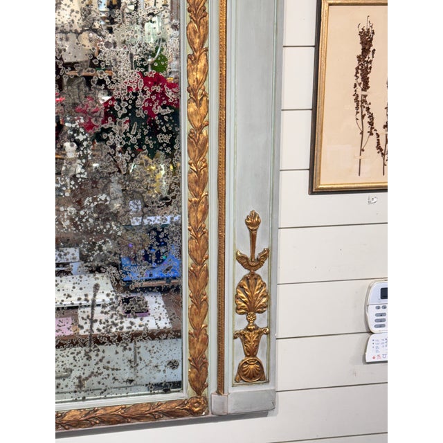 Gorgeous early 20th Century French Trumeau style mirror with muted soft gray wooden frame. The glass has a heavily...