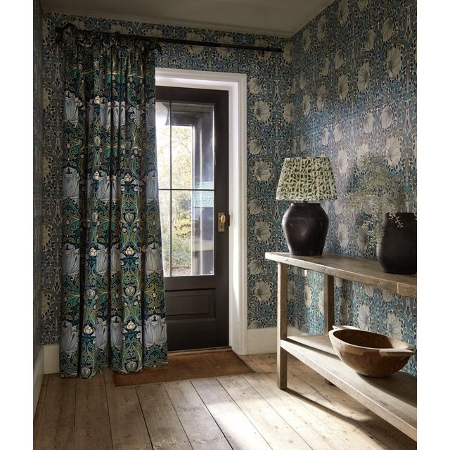 William Morris`s 1876 design Pimpernel swirls tendrils bowed in the wind. Still beloved today for its potent energy and...