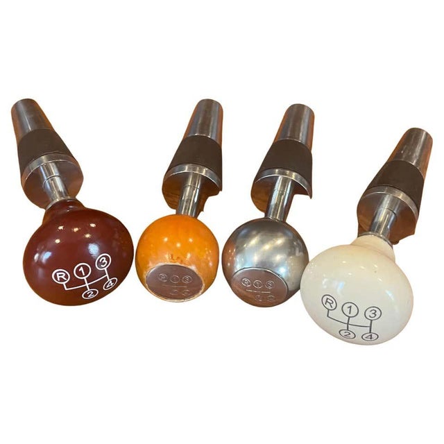 A distinctive vintage Mercedes-Benz wine accessory set featuring four bottle stoppers designed to resemble classic...