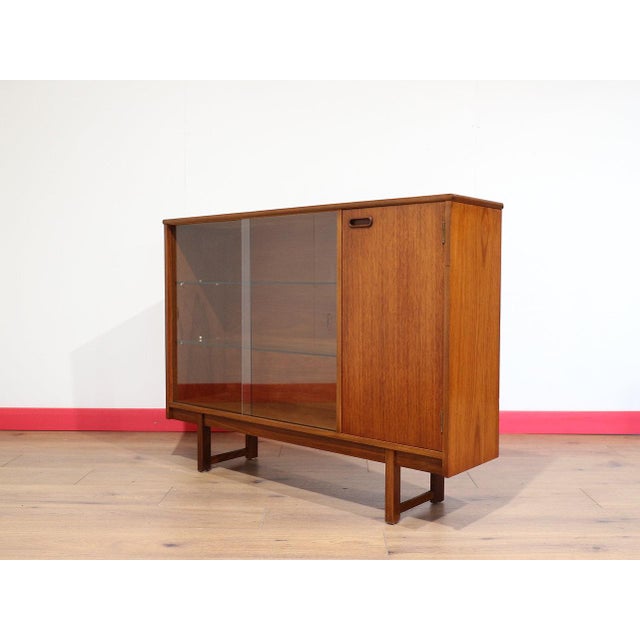 A beautiful little display cabinet showcasing the timeless elegance of Danish style, crafted from teak by the renowned...