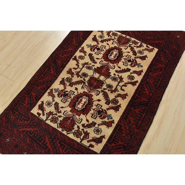 An authentic vintage tribal Baloch rug hand-knotted with fine wool and natural dyes. This nomadic oriental rug features an...