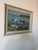 A charming 1970’s vintage oil on board landscape painting depicting a peaceful lakeside scene with several small boats...
