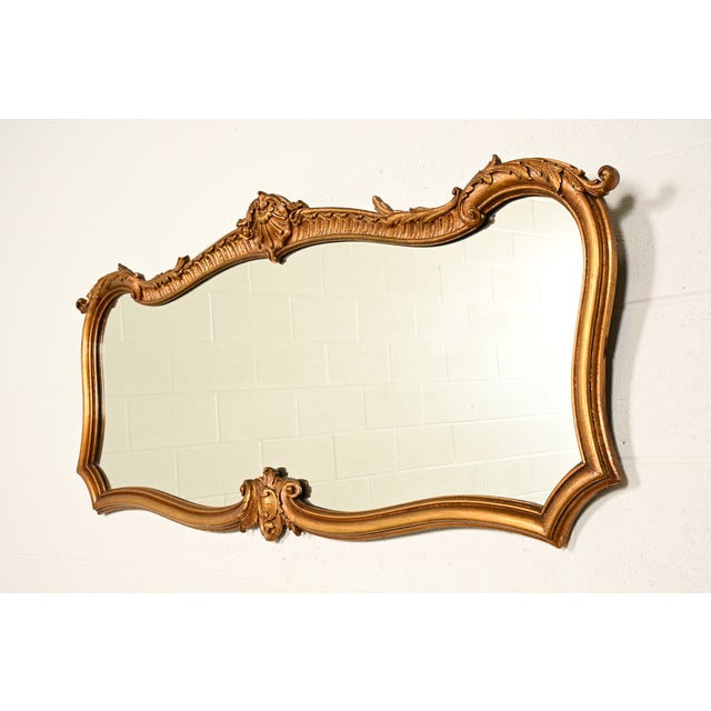A beautiful antique Italian Rococo, Louis XV, or Baroque style carved giltwood framed wall mirror Italy, Circa 1900...