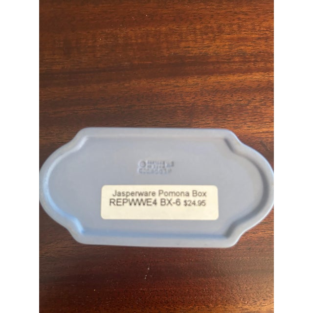 Small Wedgwood-style blue jasperware trinket box with lid, featuring the classic matte blue finish and raised white...