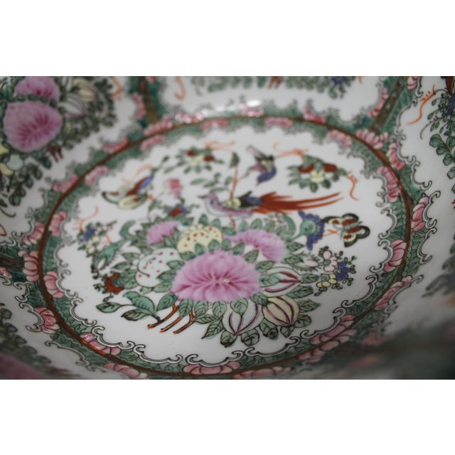 Elegant Famille Rose–style Chinese porcelain bowl featuring a richly detailed garden motif with pink peony-like blossoms,...