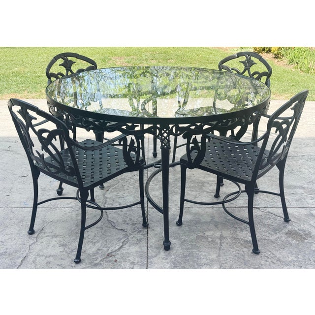 Uniquely classic vintage outdoor dining table with four chairs featuring hummingbird motif. Round black aluminum table...