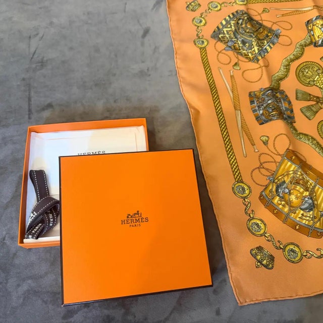 This stunning and iconic Hermès Paris silk carré scarf features the classic "Les Tambours" motif, beautifully designed by...