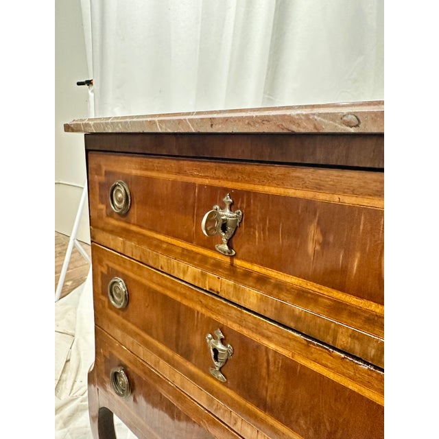 Stunning Antique Petite commode with variegated pink rectangular marble top, canted corners above a conforming case, three...
