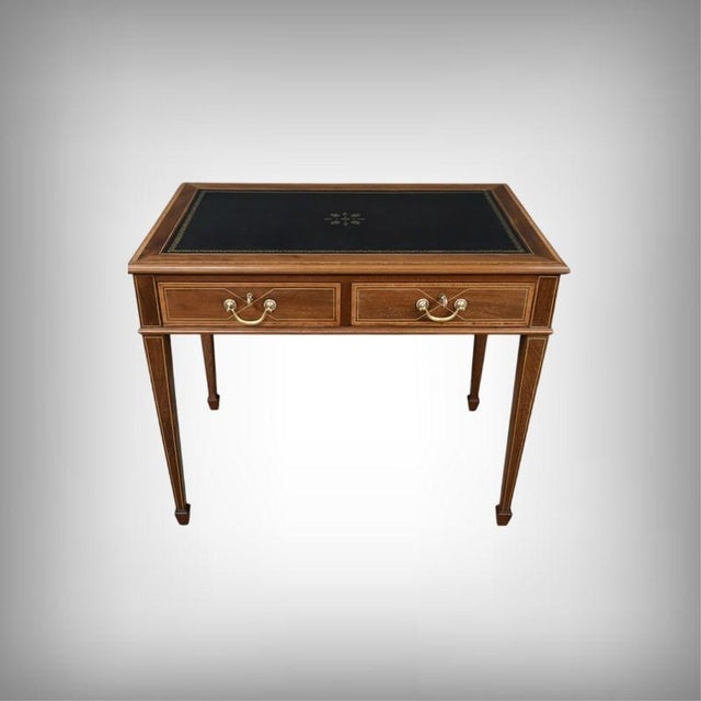 A small, flat English-style desk in mahogany and mahogany veneer, offering a striking presence thanks to the warmth of its...