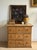 A deep antique pine chest with nine equal drawers in a 3×3 grid, each fitted with a single original turned wooden knob,...