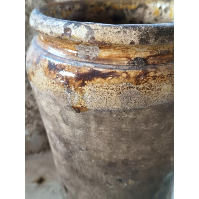 A cylindrical terracotta vase, handcrafted in Southern Italy, originally used as a pantry container. The slender shape...