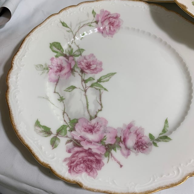 These vintage porcelain plates feature the classic pink "Baltimore Rose" floral pattern with scalloped, gilded edges,...