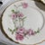These vintage porcelain plates feature the classic pink "Baltimore Rose" floral pattern with scalloped, gilded edges,...