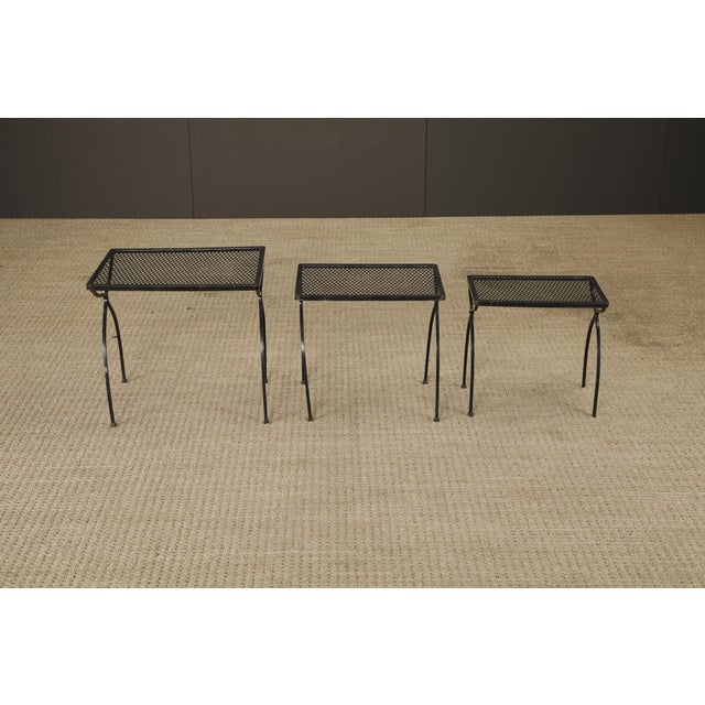 Stylish set of three vintage nesting tables featuring perforated metal mesh tops and sculptural curved legs. These tables...