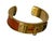This timeless Kelly Bangle is in excellent condition. This luxurious piece features gold-plated hardware and orange...