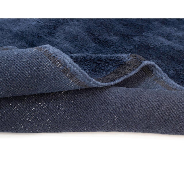 Luxurious hand-knotted rug in deep Midnight Blue, accented with a striking Midnight Black central stripe, creating a...