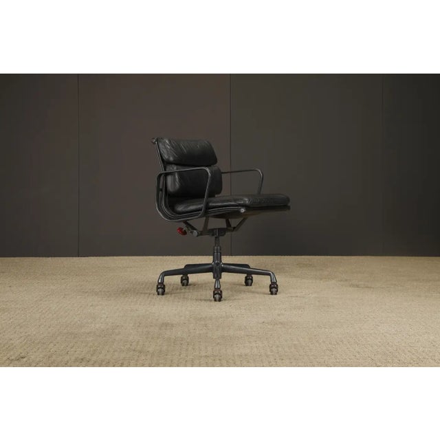 A classic of modernist comfort, this rare color way (black on black) swivel desk chair by Charles and Ray Eames for Herman...