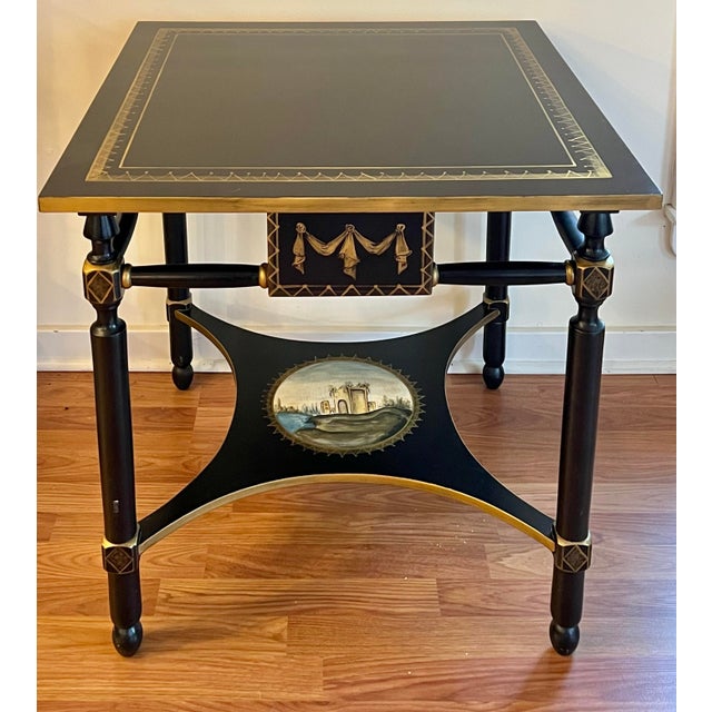 Beautiful accent table made in Italy. Ebonized with gold accents and hand painted impressionistic painting on lower shelf....