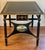 Beautiful accent table made in Italy. Ebonized with gold accents and hand painted impressionistic painting on lower shelf....