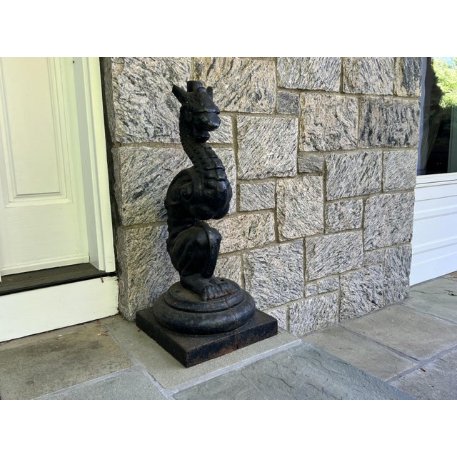 A pair of large, heavy and whimsical cast iron figural dragons or griffins door statues on square tiered bases. No maker’s...