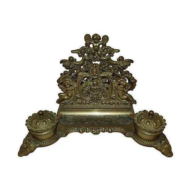 Antique French bronze double inkwell ornately decorated with cherubs, removable bronze ink cups and lidded tops. Top rack...