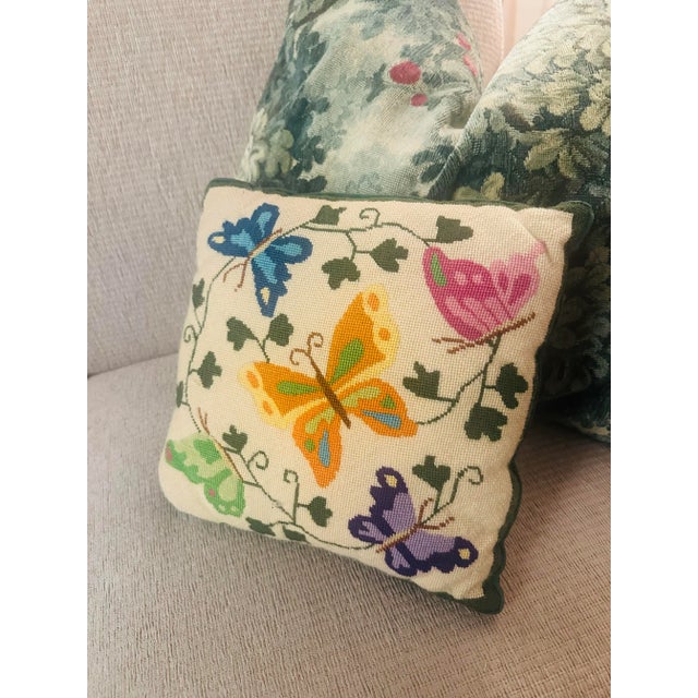 This is a hand-stitched needlepoint decorative pillow featuring a lively butterfly motif. Design & Detailing • Front: The...