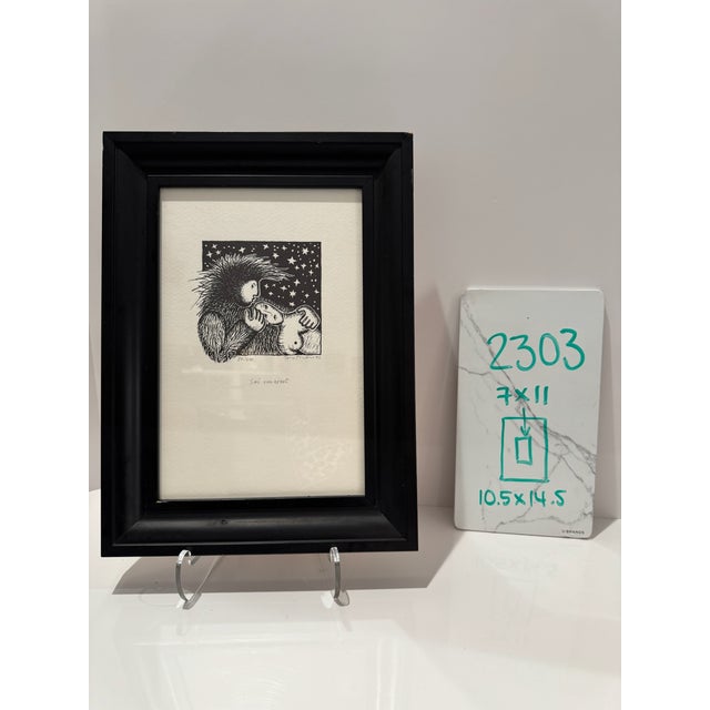 Signed and numbered woodblock print by Irena Martens titled “Sei Umarmt.” The black-and-white composition depicts two...