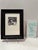 Signed and numbered woodblock print by Irena Martens titled “Sei Umarmt.” The black-and-white composition depicts two...