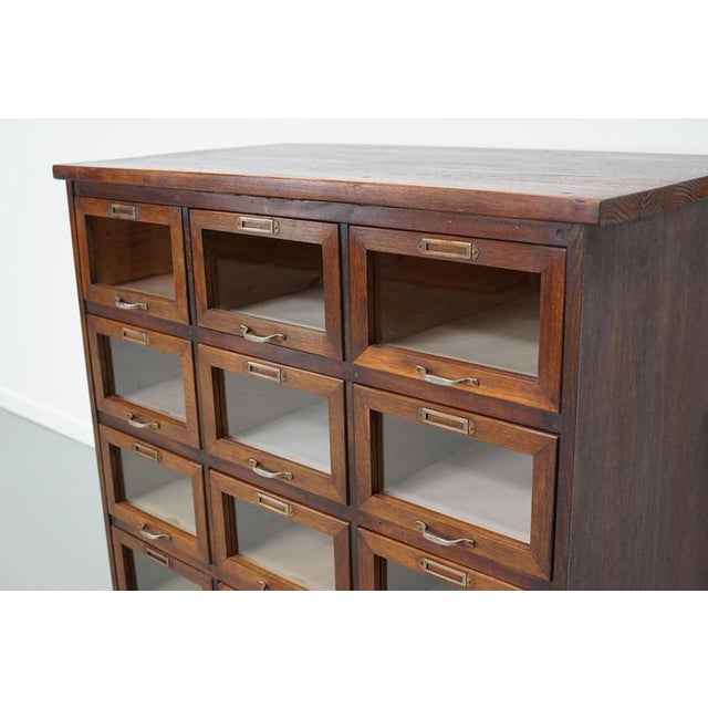 This haberdashery cabinet was produced during the 1950s in the Netherlands. It features 12 drawers in oak with glass...
