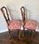 A charming pair of vintage French Provincial side chairs featuring sculptural interlocking ribbon—or “pretzel”—backs and...