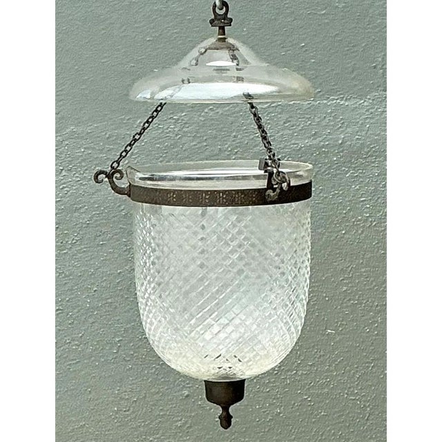 This bell jar lantern pairs faceted crystal with aged metalwork in a form long associated with grand colonial-era...