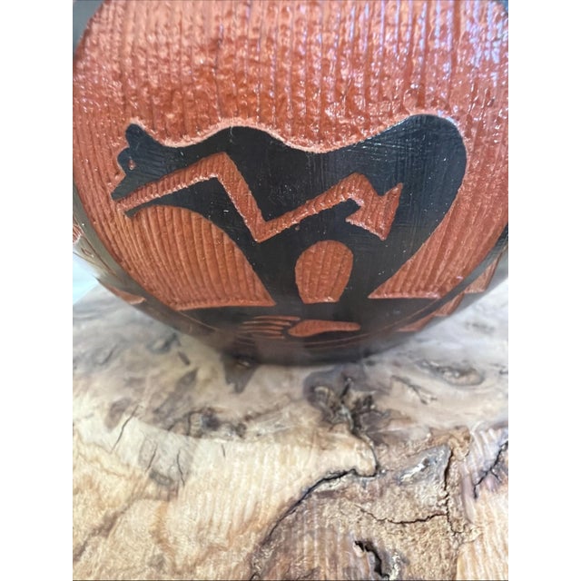 Handcrafted signed Navajo pottery bowl featuring a bold bear motif in red and black. This piece is signed on the base...