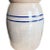 This fine ceramic butter churn or crock is in fine condition for its age. Its body is cream, with a fluted top. Two blue...