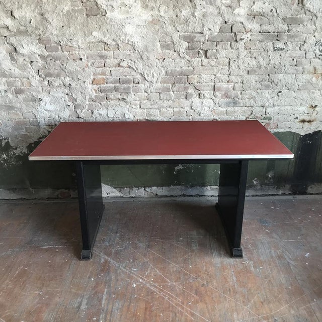 Beautiful Industrial table with a red linoleum tabel top and and black base. The table shows traces of use, like some...