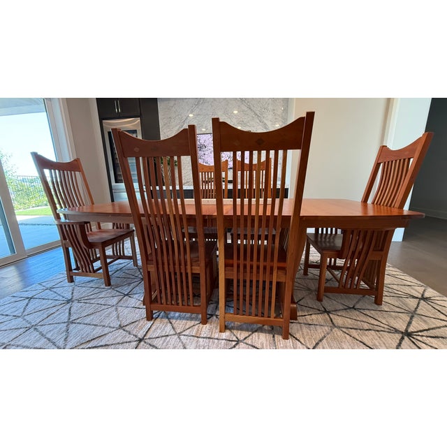 A stunning example of American craftsmanship, this heirloom-quality dining set was meticulously handcrafted by Amish...