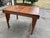 A beautifully crafted early 20th-century oak dining table featuring hand-carved Jacobean Revival detailing and a solid...