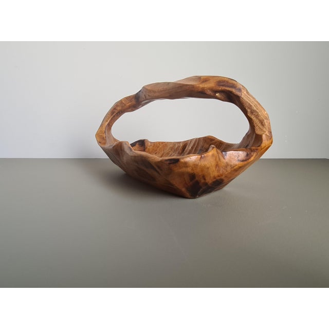 Elegant hand-carved basket from a solid block of wood, featuring a beautiful sculptural organic shape and an integrated...