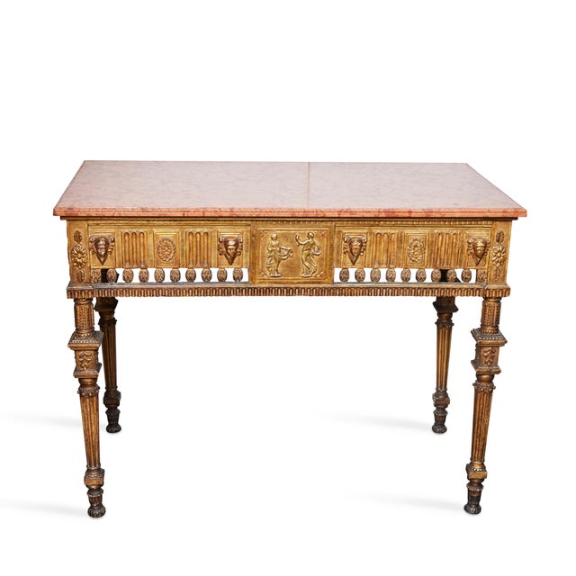 Neoclassical hand carved, gilt wood console with a polished rouge marble top. The marble top has a carved molded edge, the...
