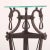 An elegant wrought iron plant stand or pedestal, featuring a round glass top supported by a tapering tripod base. The...