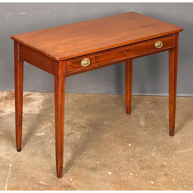 A handsome English writing table or desk (or side table) of mahogany from the Edwardian era, featuring a moulded...