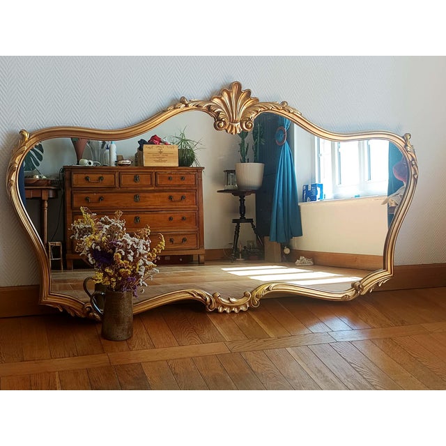 Large mirror in wood and gilt stucco, molded with a shell and acanthus leaf motif. Louis XV style, circa 1970/80. In...