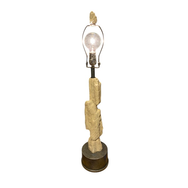 A beautiful designer Palecek lamp featuring a textured faux stone column that resembles hand-carved rock, giving it an...
