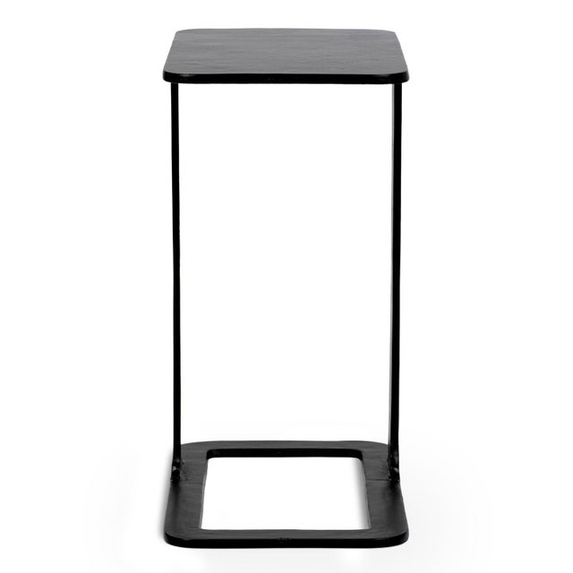 Modern cast aluminum end table with a sleek black finish. Its sculptural cantilever silhouette offers a refined functional...