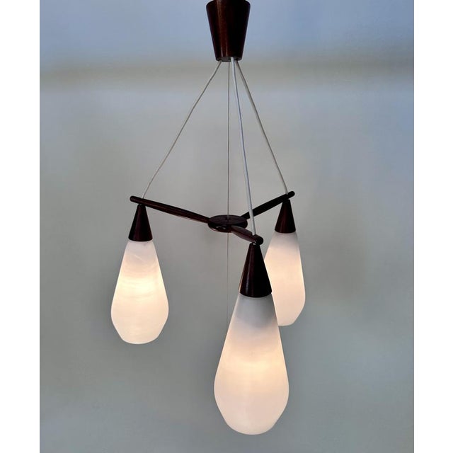 This early danish design drop hanging lamp was manufactured during the 1950s. It features opaline glass lampshades which...