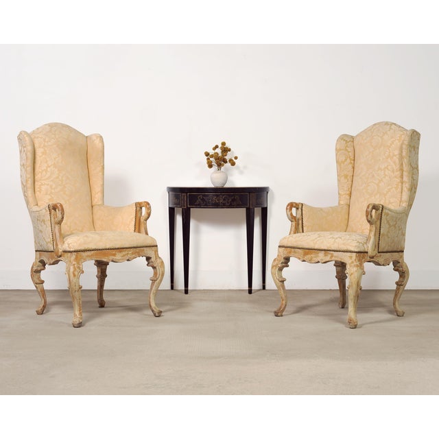 A charming pair of tall wingback bergère armchairs in the Country French Provincial Louis XV style. The large beech wood...