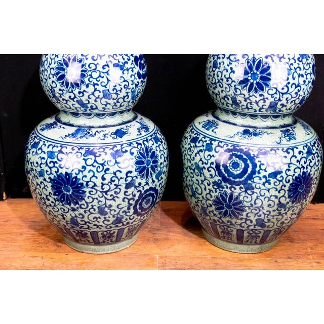 Breathtaking pair of chinese blue and white porcelain urns double gourd form with intricate hand painted arabesques and...
