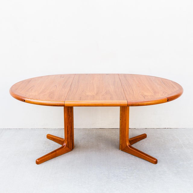 Vintage mid century modern expandable teak dining table on split pedestal base in newly refinished condition. The solid...