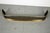 A long, curved fireplace fender with a serpentine (bowed) front and rolled brass top rail and base and pierced iron panel...